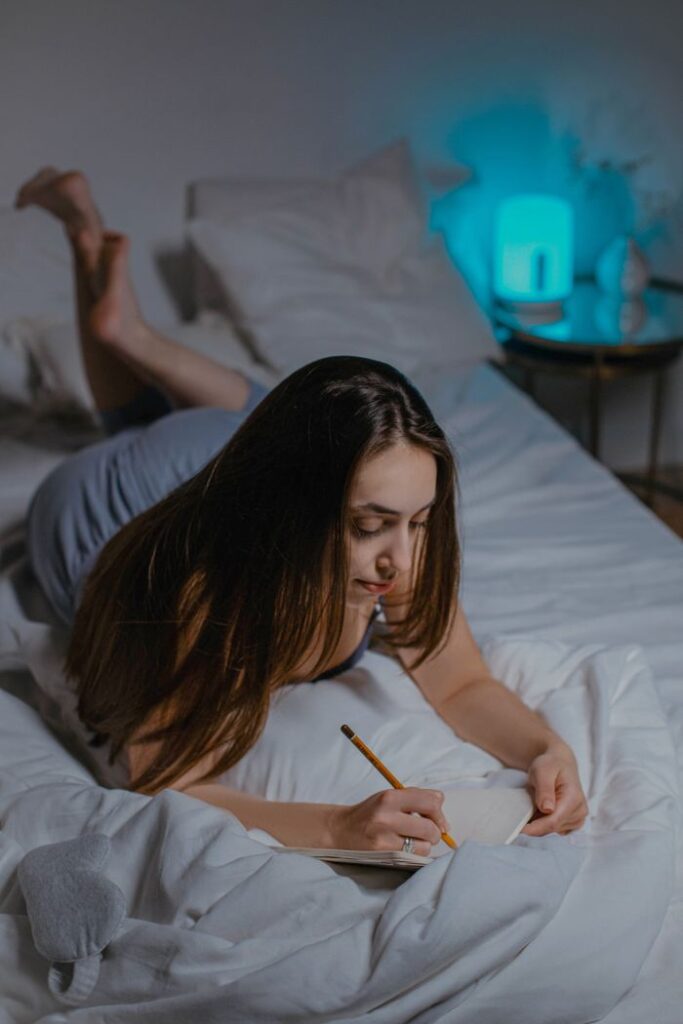 evening wind-down routine — woman journaling before bed