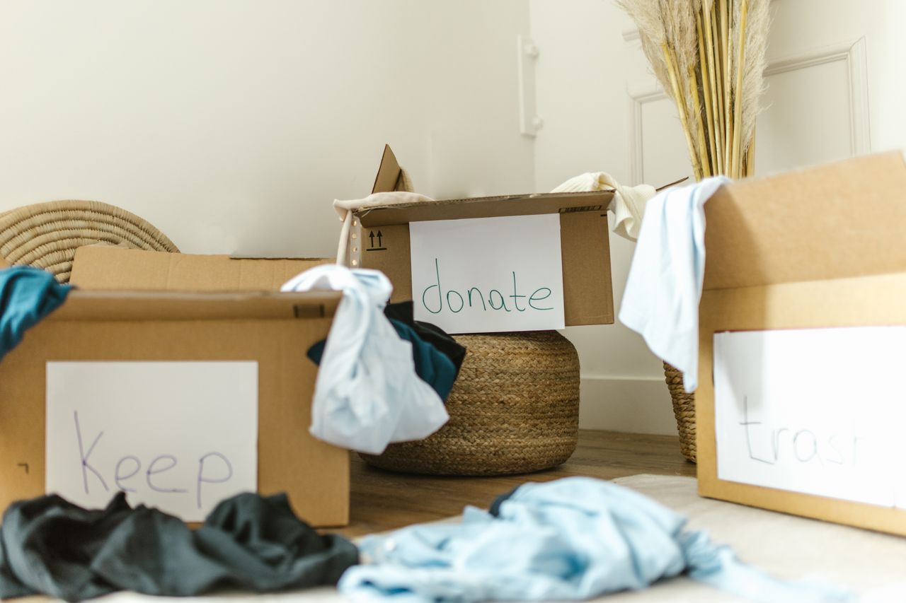 declutter your bedroom — sorting closet clothes into keep and donate piles